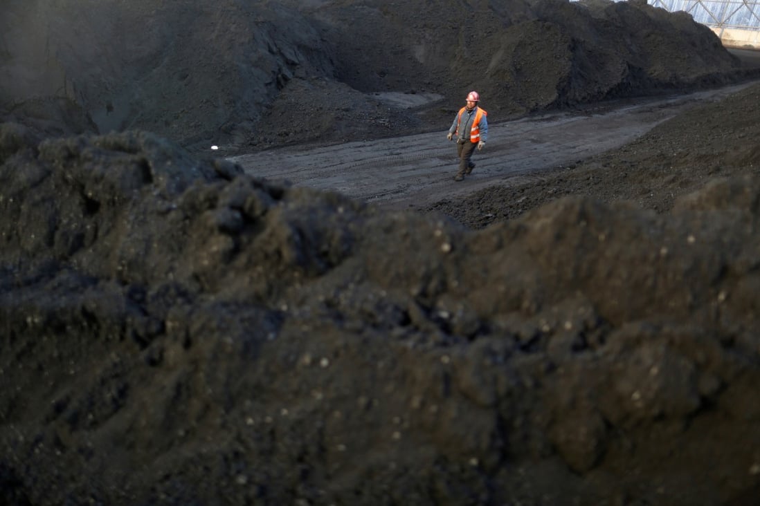 A worker walks past coal piles at a coal coking plant in Yuncheng, Shanxi province, one of China’s heavily industrial regions in the North. Photo: Reuters