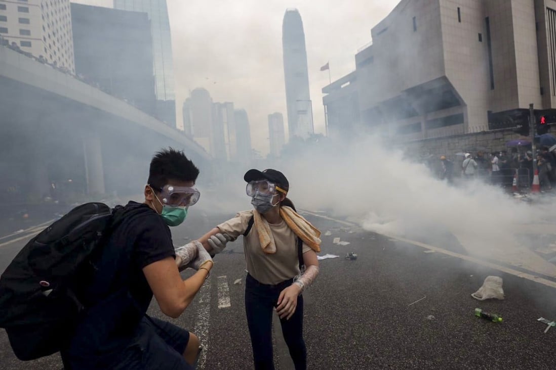Anti-extradition bill protesters run away from a cloud of tear gas fired by Hong Kong police during protests on June 12. Photo: Sam Tsang