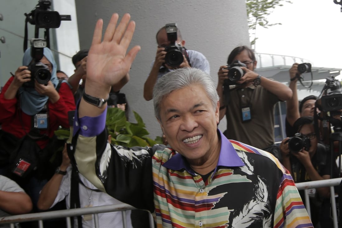 Malaysia’s former deputy prime minister, Zahid Hamidi, waves as he arrives at the Anti-Corruption Commission. Photo: EPA