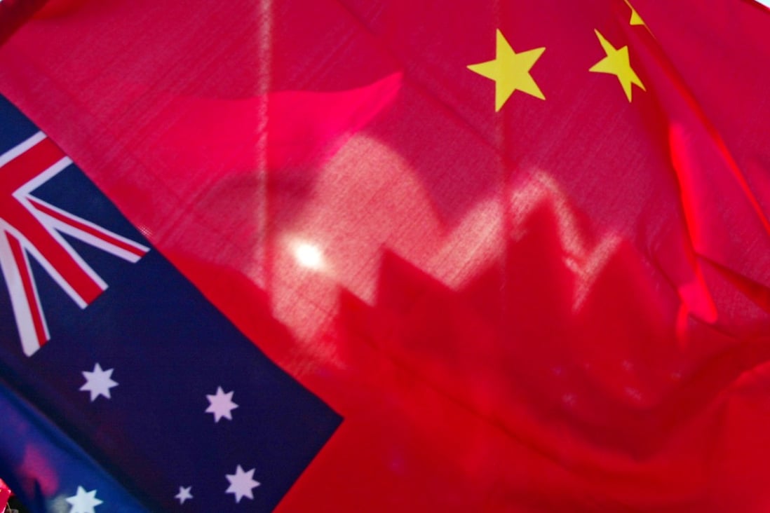 Sydney Opera House seen through a Chinese flag, with an Australian flag in the foreground. Photo: AFP