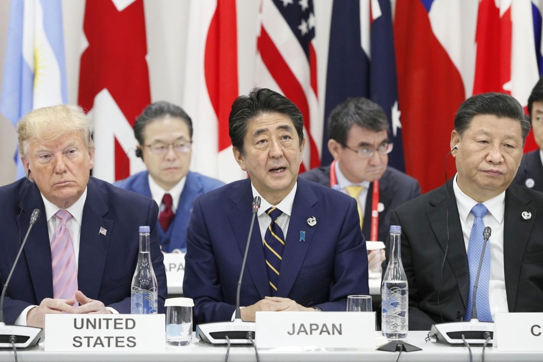 Japanese Prime Minister Shinzo Abe (centre) speaks at the G20 summit in Osaka on Friday, flanked by US President Donald Trump and Chinese leader Xi Jinping. Photo: Kyodo