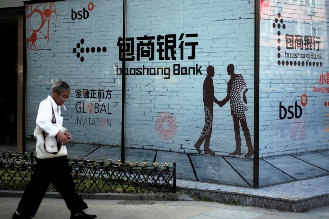 A man walks past a building with an advertisement for Baoshang Bank, in Beijing in September 2018. Photo: Reuters