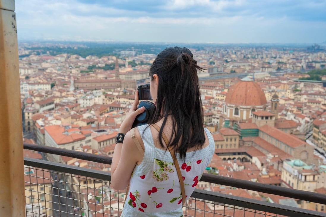 A tourist takes a photo from the observation platform on the dome of Florence Cathedral in Italy. Photo: Handout