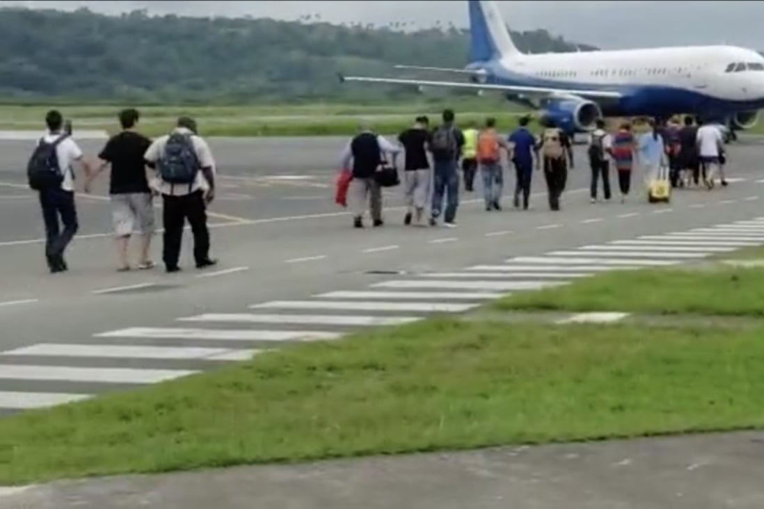 Plain clothes Chinese officers, accompanied by Vanuatu police, marching six Chinese nationals onto a chartered jet bound for China on July 6. Photo: Weibo