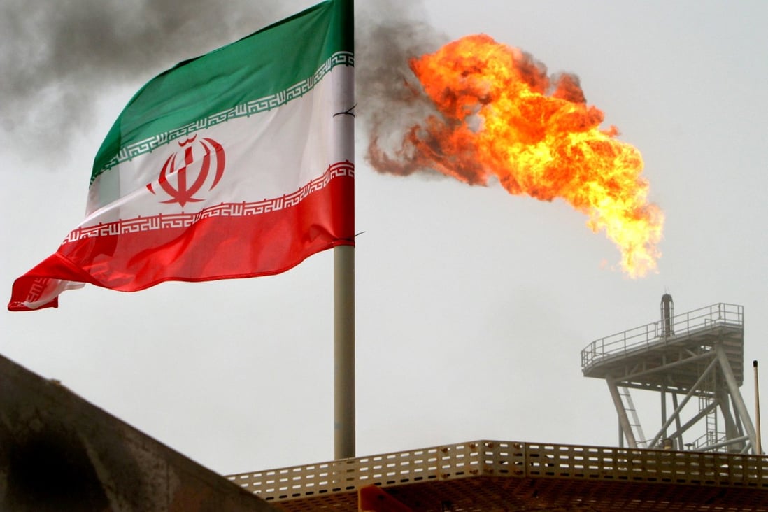 A gas flare on an oil production platform in the Soroush oilfields is seen alongside an Iranian flag in July 2005. Photo: Reuters