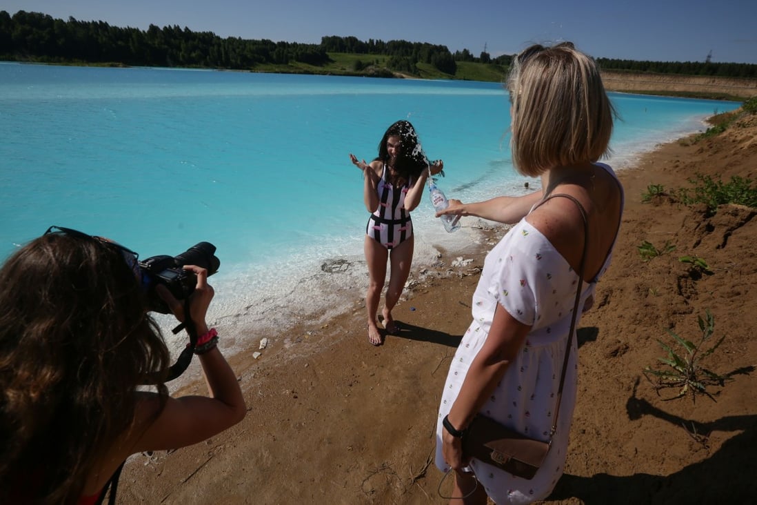 A young woman poses for pictures by a Novosibirsk energy plant's ash dump site on Thursday. Photo: AFP