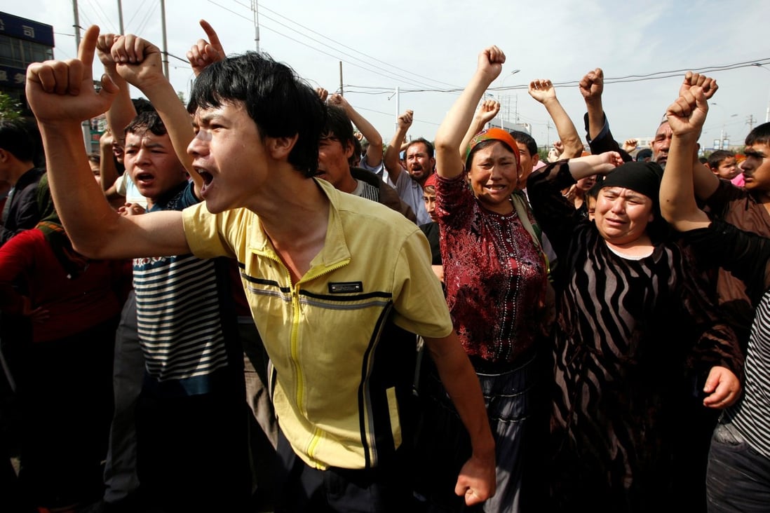 An angry crowd clashes with Chinese paramilitary police in Xinjiang. Photo: Reuters