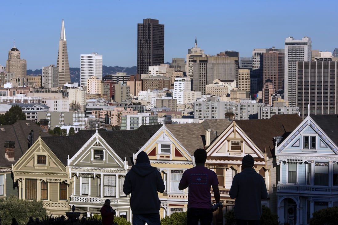 Pedestrians stand in front of Victorian homes and the downtown skyline in San Francisco, California. Chinese investment in US homes fell in the past year. Photo: Bloomberg