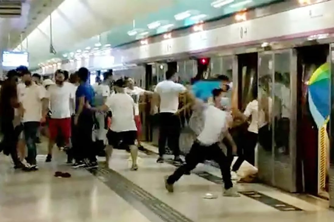 A screen grab from a video shows a group of people in white with wooden sticks chasing and assaulting passengers at the Yuen Long MTR station. Photo: Handout
