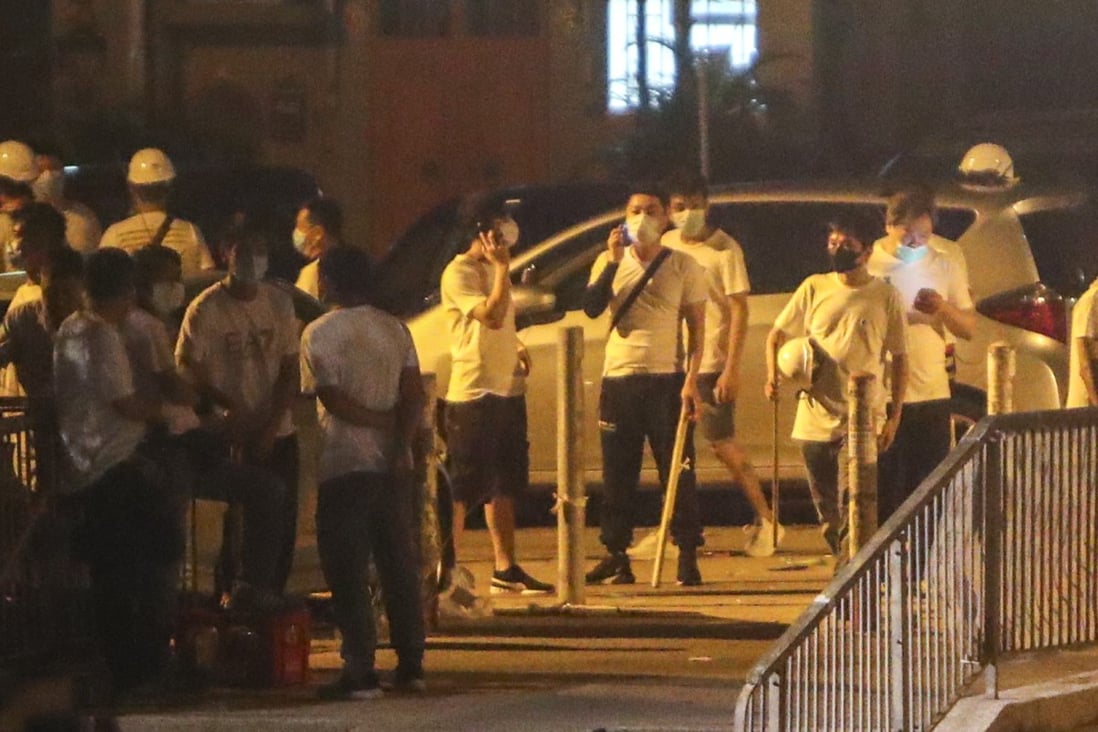 Men wearing white T-shirts and wielding weapons stand on the streets of Yuen Long on Sunday night, which descended into mob violence. Photo: Winson Wong