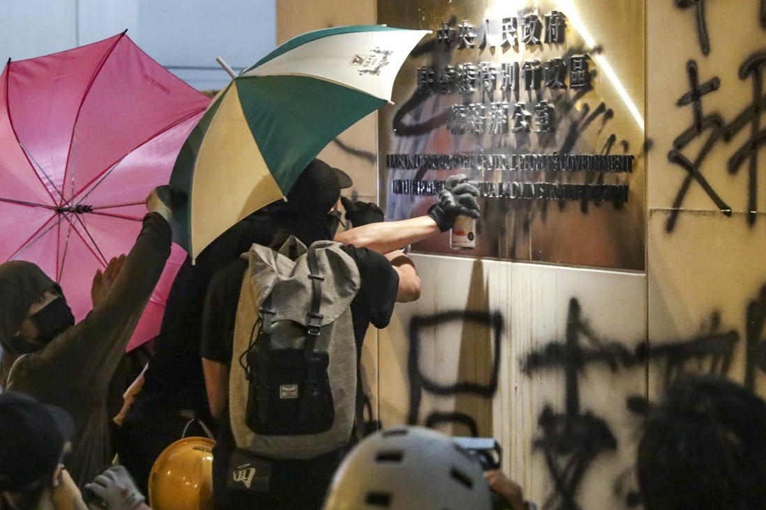 Protesters deface the wall of the central government’s liaison office in Hong Kong on Sunday. Photo: Edmond So
