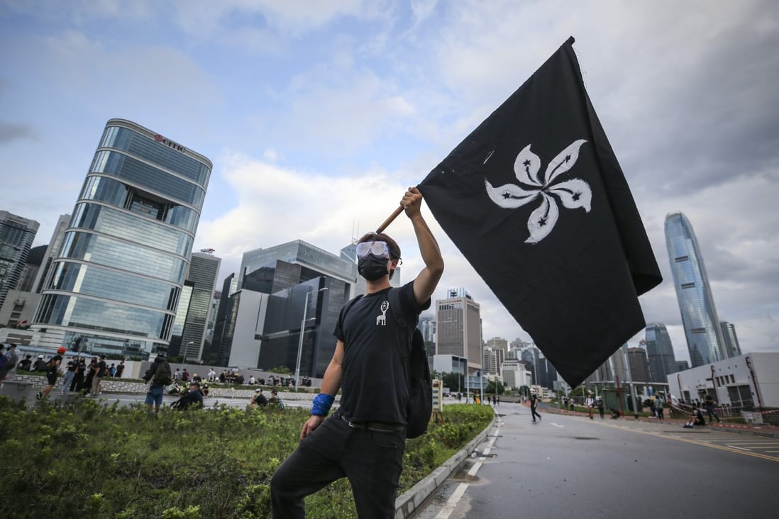A protester holding up a black Hong Kong flag while marching against the extradition bill outside the Legislative Council in Tamar, Admiralty, on the 22nd anniversary of Hong Kong’s handover from Britain to China on July 1. Photo: Winson Wong