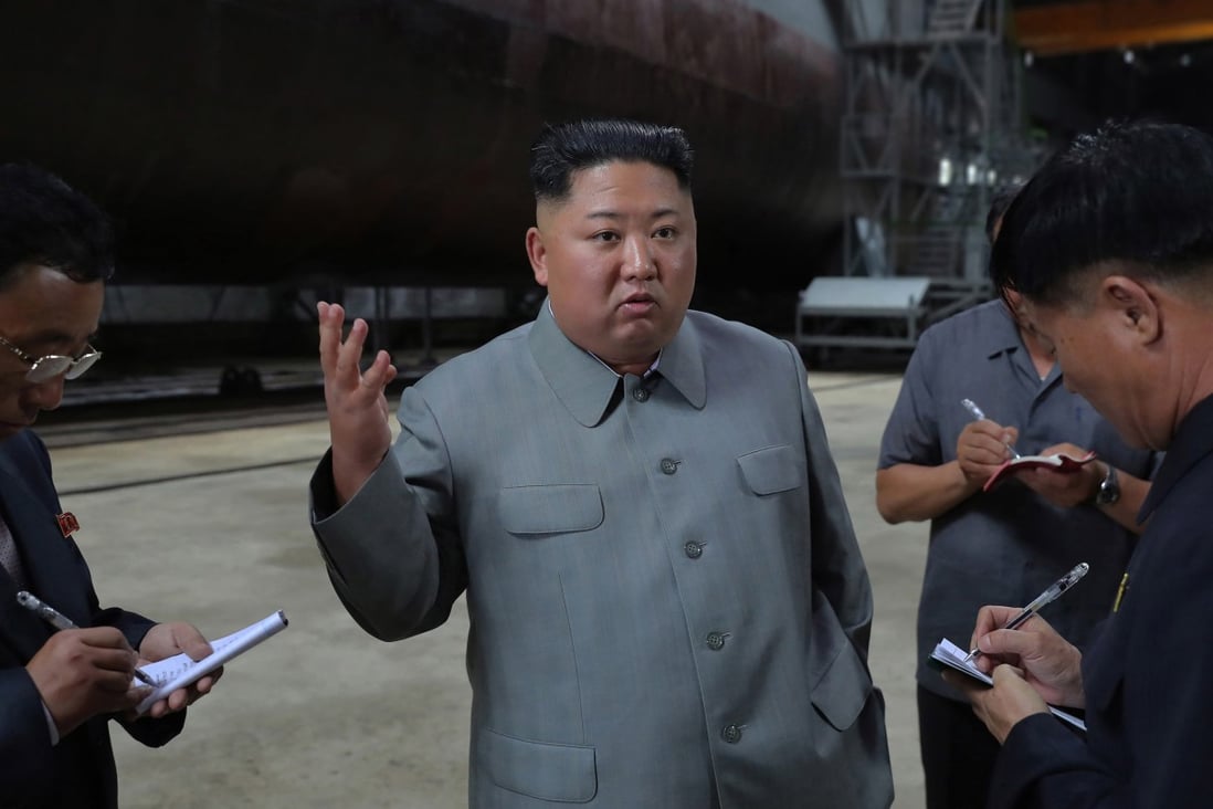 Kim Jong-un speaking to officials after making a round of the newly laid down submarine at an undisclosed location in North Korea. Photo: EPA-EFE/KCNA
