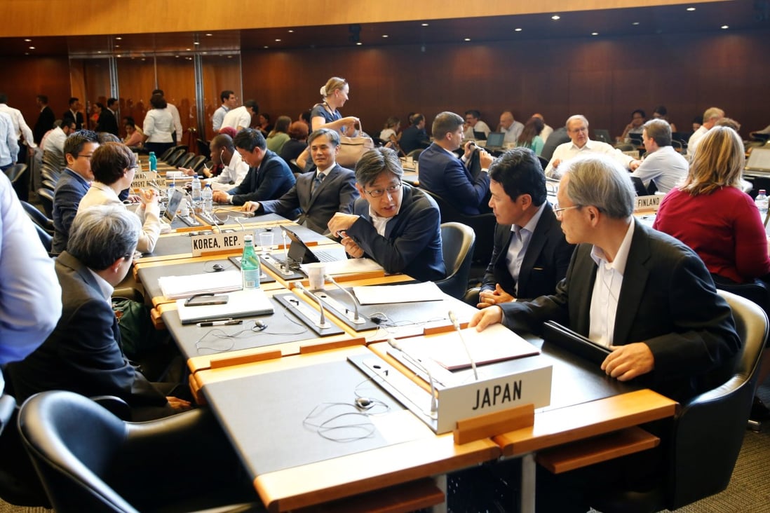 Members of the South Korea and Japan delegations arrive for the General Council meeting. Photo: Reuters