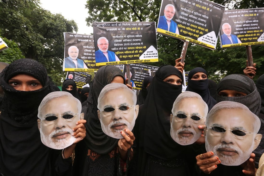 Indian Muslim women wearing masks depicting Indian Prime Minister Narendra Modi celebrate passing a law outlawing instant divorce practice. Photo: EPA-EFE