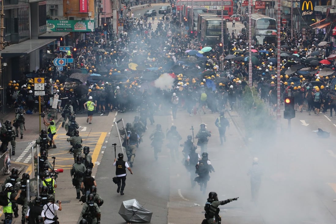Riot police run towards anti-government protesters in Sham Shui Po during another day of clashes across Hong Kong on Sunday. Photo: Felix Wong