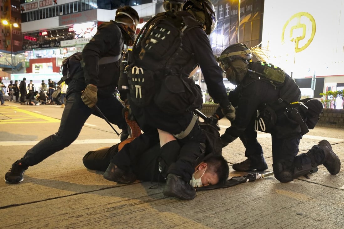 A protester is restrained by three police officers during clashes in Hong Kong. Photo: James Wendlinger