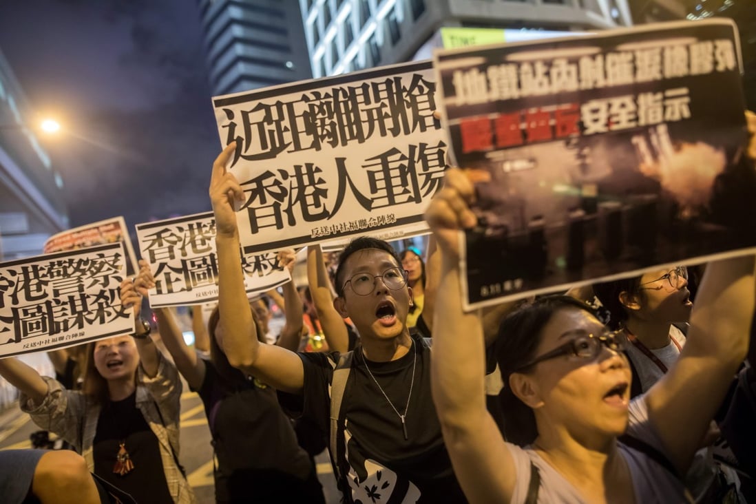 Demonstrators hold placards and shout slogans during a protest outside the police headquarters building in the Wan Chai district of Hong Kong on Monday. Photo: Bloomberg