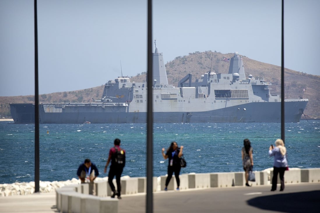 Visitors pose for photos outside Apec Haus in Papua New Guinea in November, with the USS Green Bay anchored just offshore in Port Moresby. Photo: AP