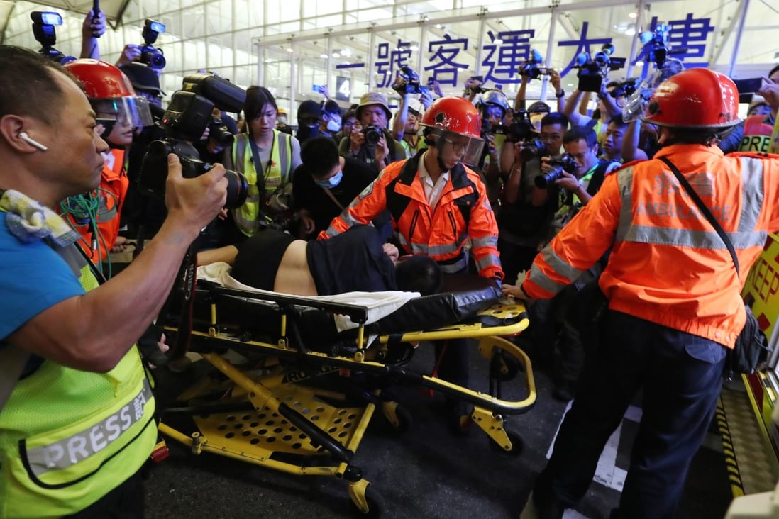 Global Times reporter Fu Guohao is taken to an ambulance by paramedics after being tied up by anti-government protesters at Hong Kong International Airport on Tuesday night. Photo: Sam Tsang