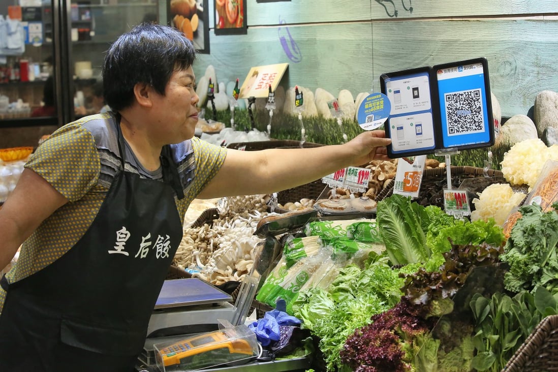 A Hong Kong merchant uses Ant Financial Services Group's Alipay at her stall in Po Tat Market. Photo: Edmond So