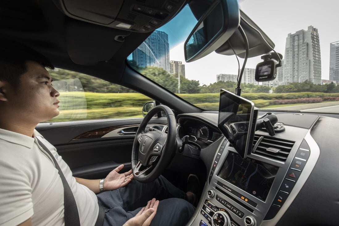 An employee sits behind the steering wheel of a Pony.ai Inc. autonomous vehicle as it travels along a road. Photo: Bloomberg