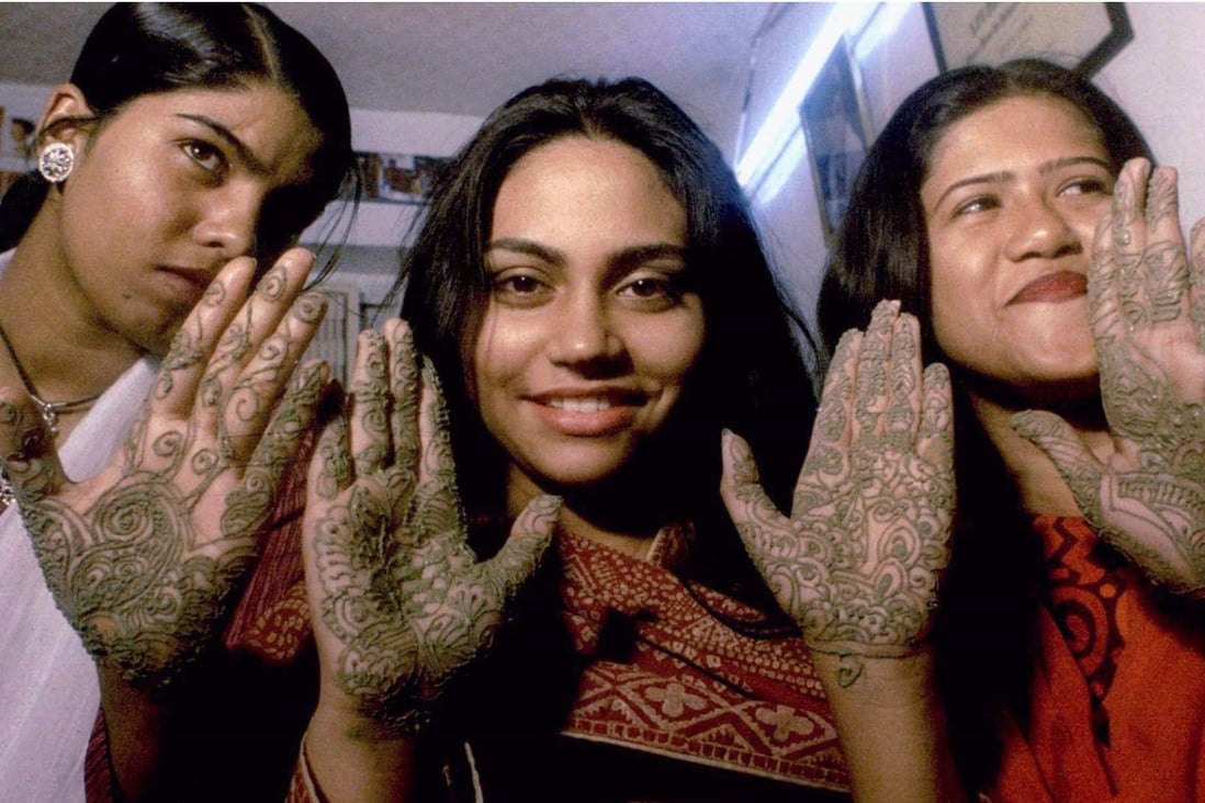 Bangladeshi women show their palms painted with henna at a beauty parlour in Dhaka. Photo: Reuters