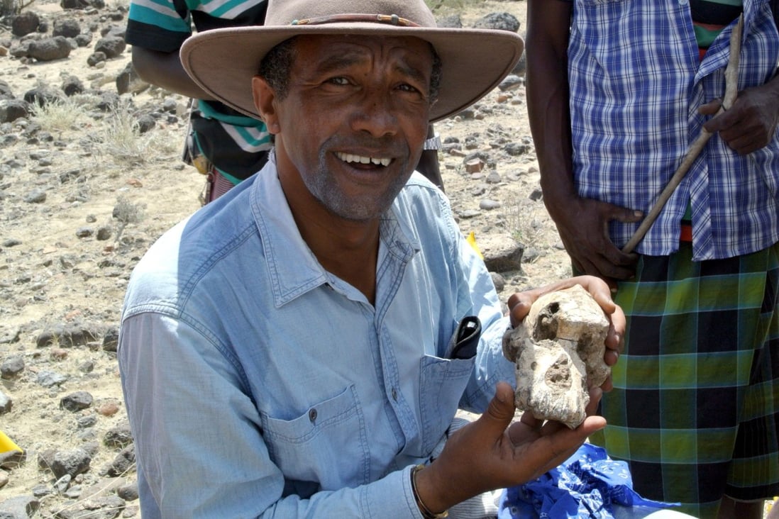 Yohannes Haile-Selassie posing with a fragment of Australopithecus skull in Ethiopia. Photo: Handout via AFP