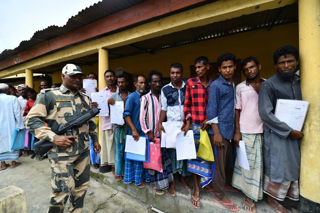 Assam residents queue under guard to check their names against the National Register of Citizens list. Photo: AFP