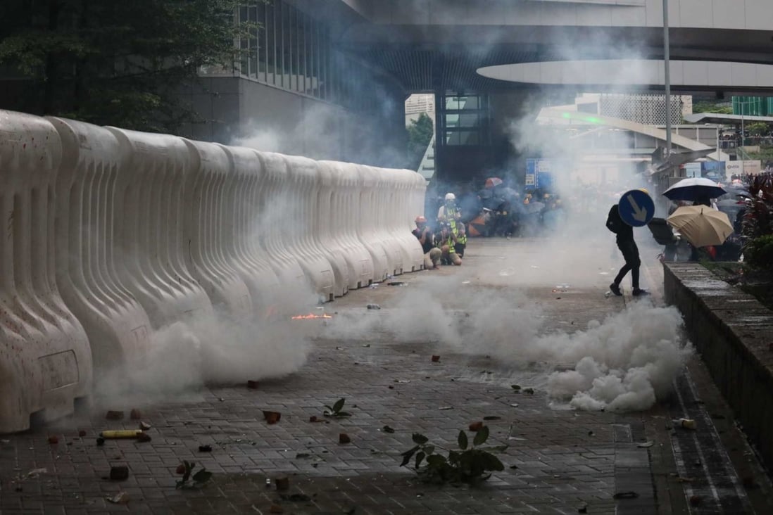 An anti-government protester struggles with riot police on Harcourt Road on Saturday. Photo: Felix Wong