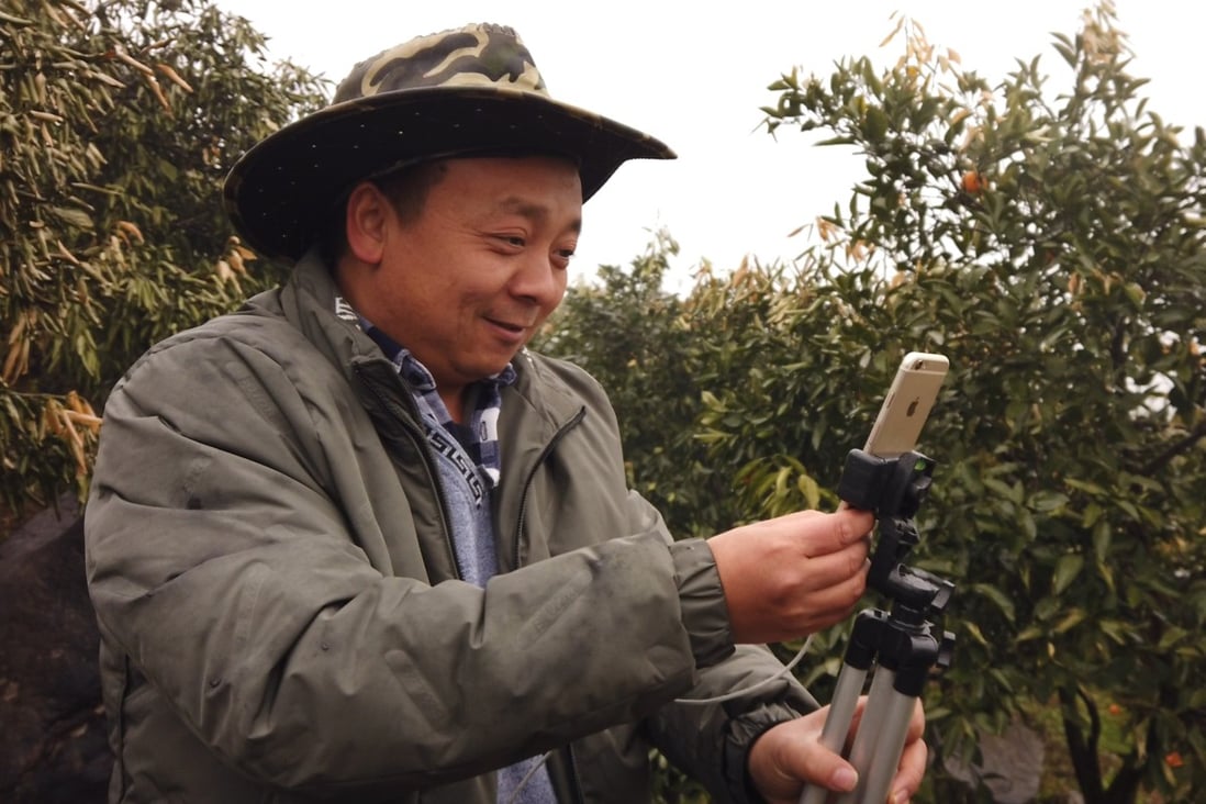 Zhong Haihui, a fruit farmer from central China's Hunan province, uses an iPhone 6, a small tripod and a power bank when live-streaming video for short video app operator Kuaishou and e-commerce platform Taobao Marketplace. Photo: Chris Chang