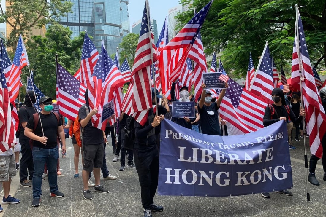 Protesters on the march wave US flags. Photo: Simone McCarthy