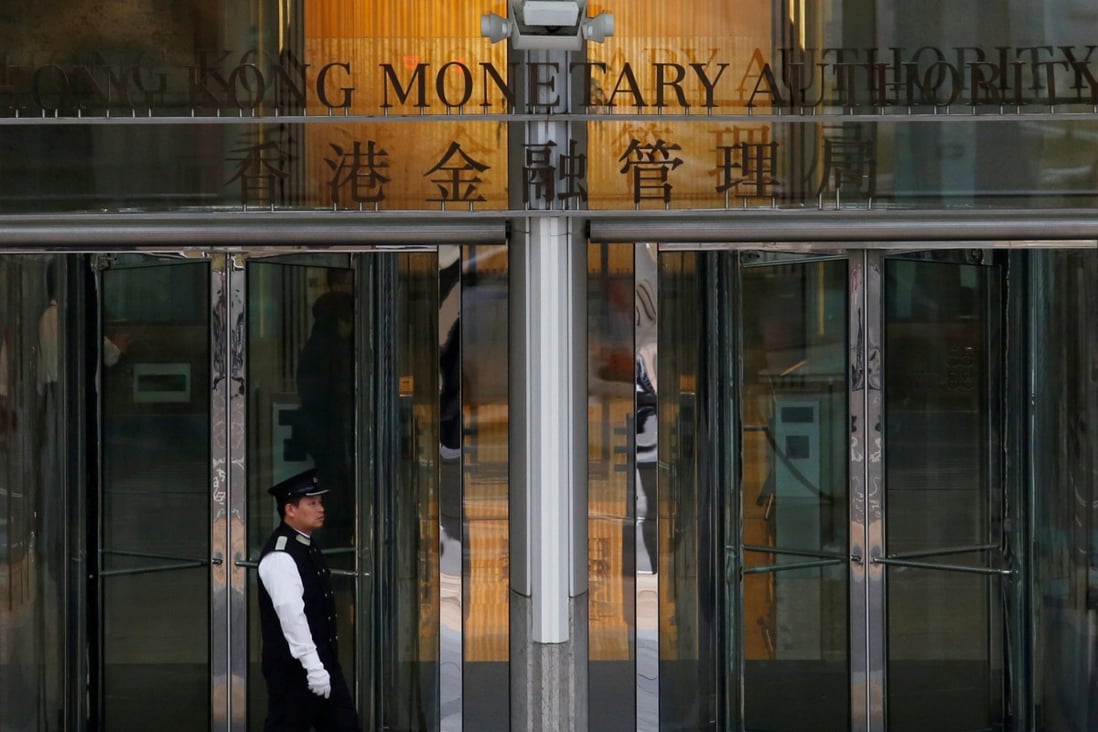 An attendant walks outside the entrance to the Hong Kong Monetary Authority offices in November 2015. Photo: Reuters
