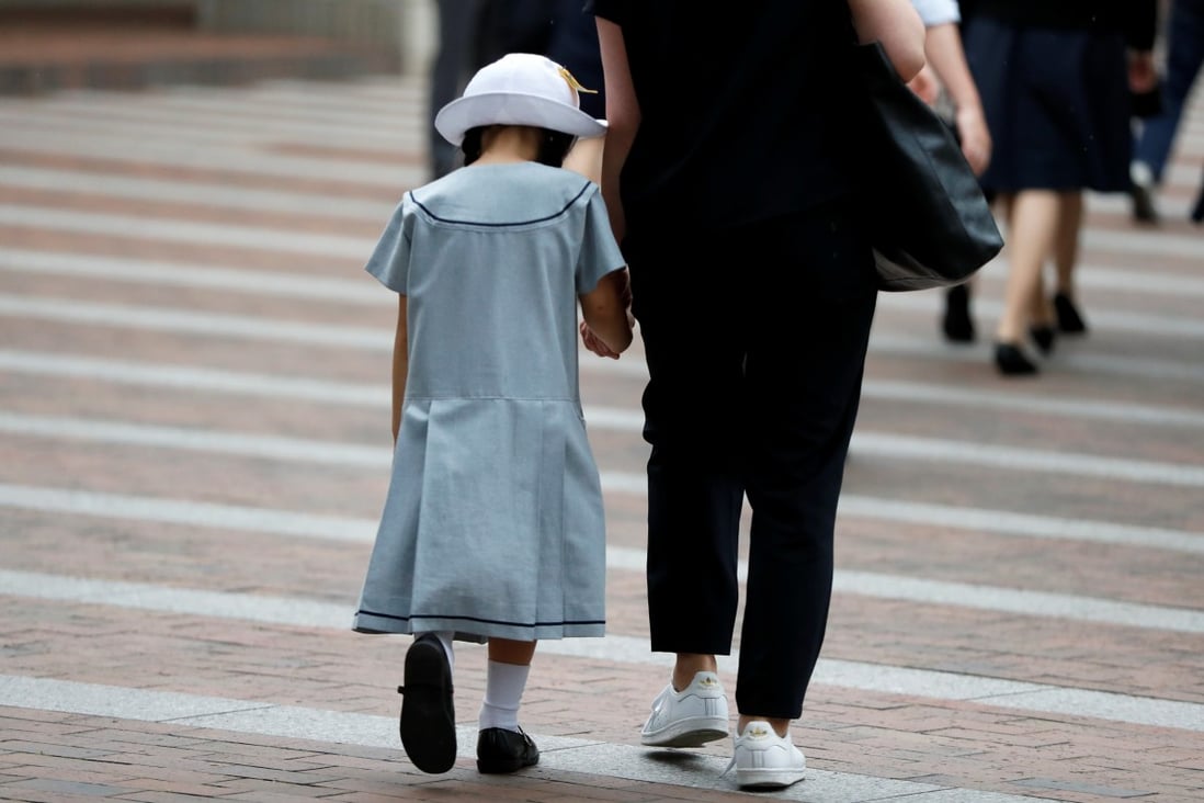 A student and her mother enter a school in Kawasaki, Japan. Photo: Reuters