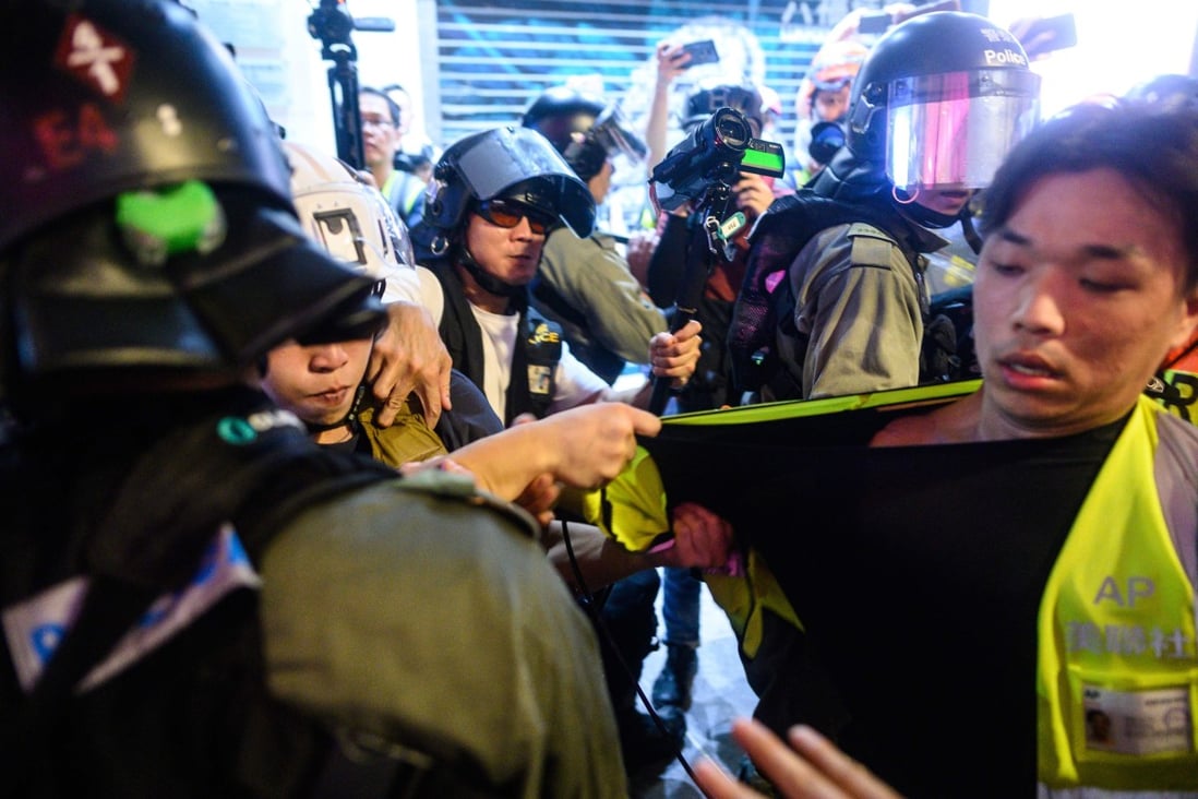 A video journalist is jostled during a protest in Causeway Bay on September 8. Photo: AFP