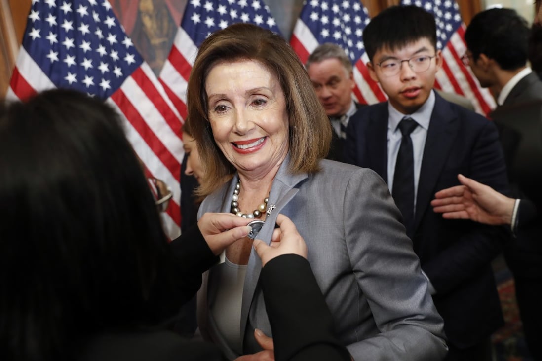 US House speaker Nancy Pelosi is given a lapel pin by an activist following the news conference Wednesday at the Capitol in Washington. Behind Pelosi is Hong Kong activist Joshua Wong. Photo: AP