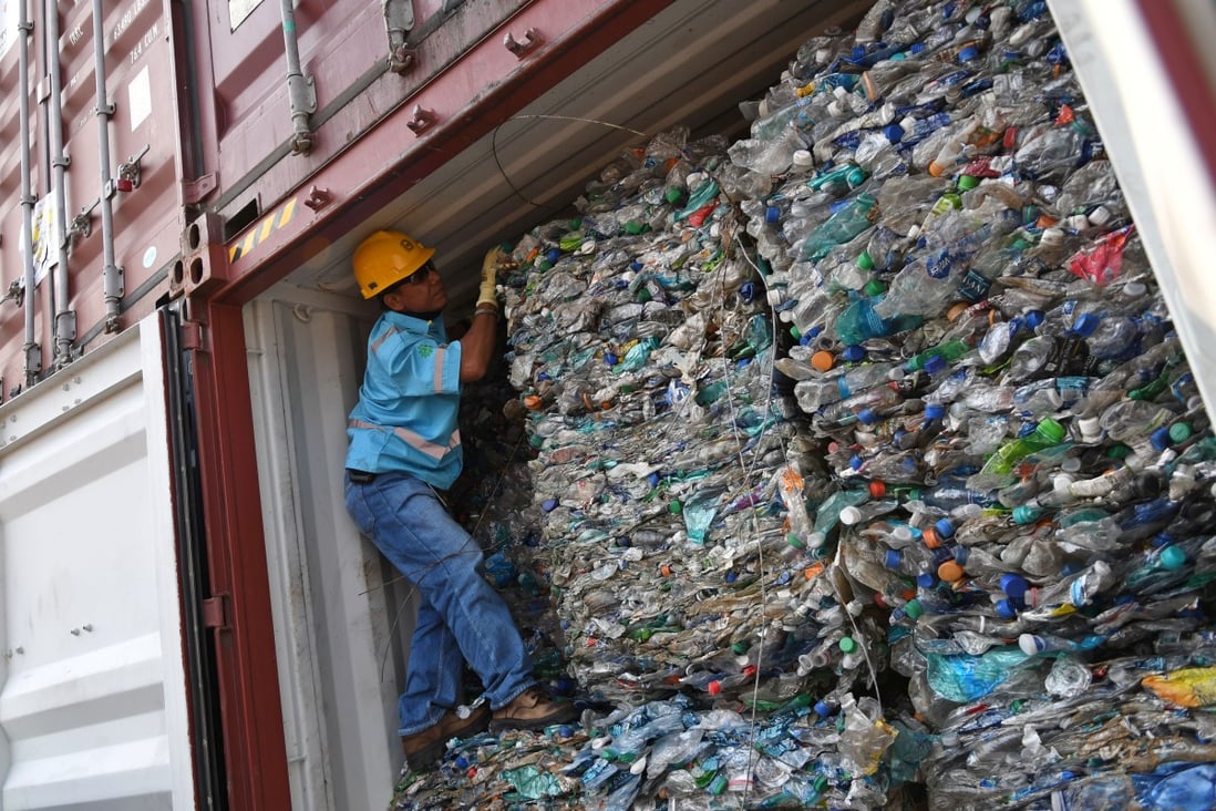 An officer stands inside a container full of plastic waste at Tanjung Priok port in Jakarta. Photo: Antara Foto via Reuters