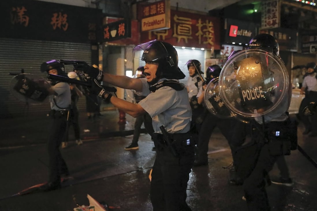 Police officers pull out their guns after a confrontation with demonstrators during a protest in Hong Kong, in August. Photo: AP