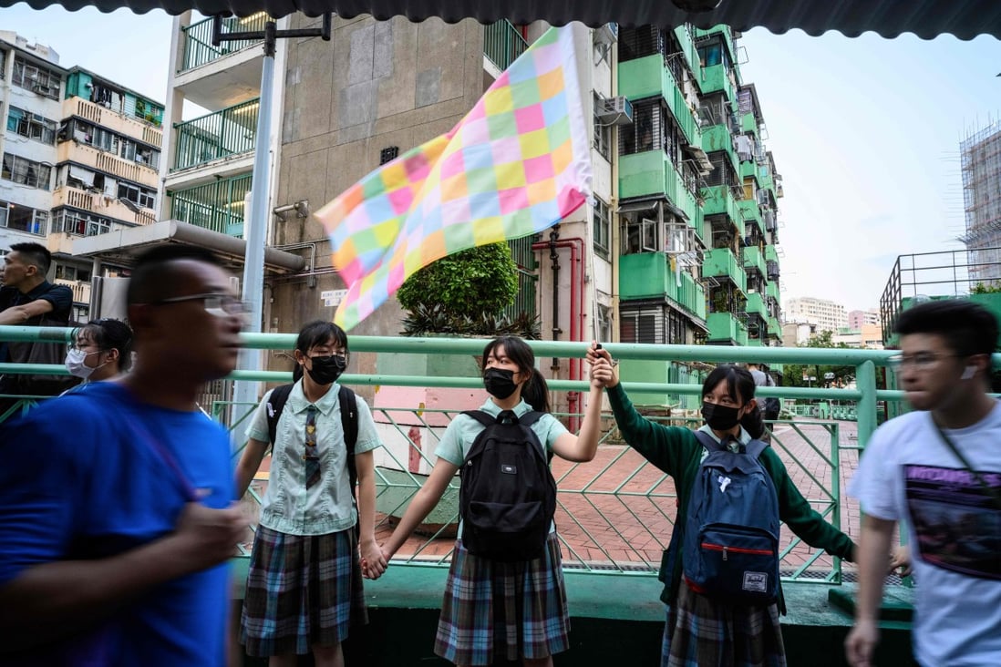 A student holds a “Lennon Wall flag”, designed by Australia-based Chinese political artist Badiucao, as she and others join hands to form a human chain in Hong Kong’s Kwun Tong district, on September 24. Photo: AFP