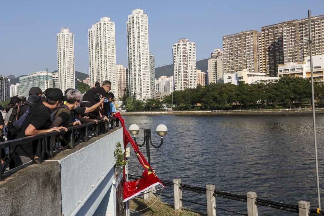 Anti-government protesters throw a torn Chinese national flag into Shing Mun River in Sha Tin on September 22. Photo: Nora Tam