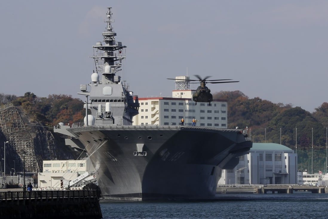 A Japanese helicopter prepares to land on the flight deck of the Izumo. Photo: AP