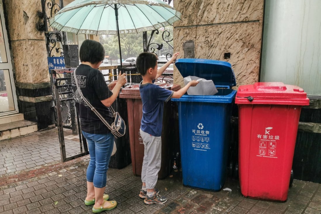 A child puts plastic delivery bags into a recycling bin. Photo: EPA