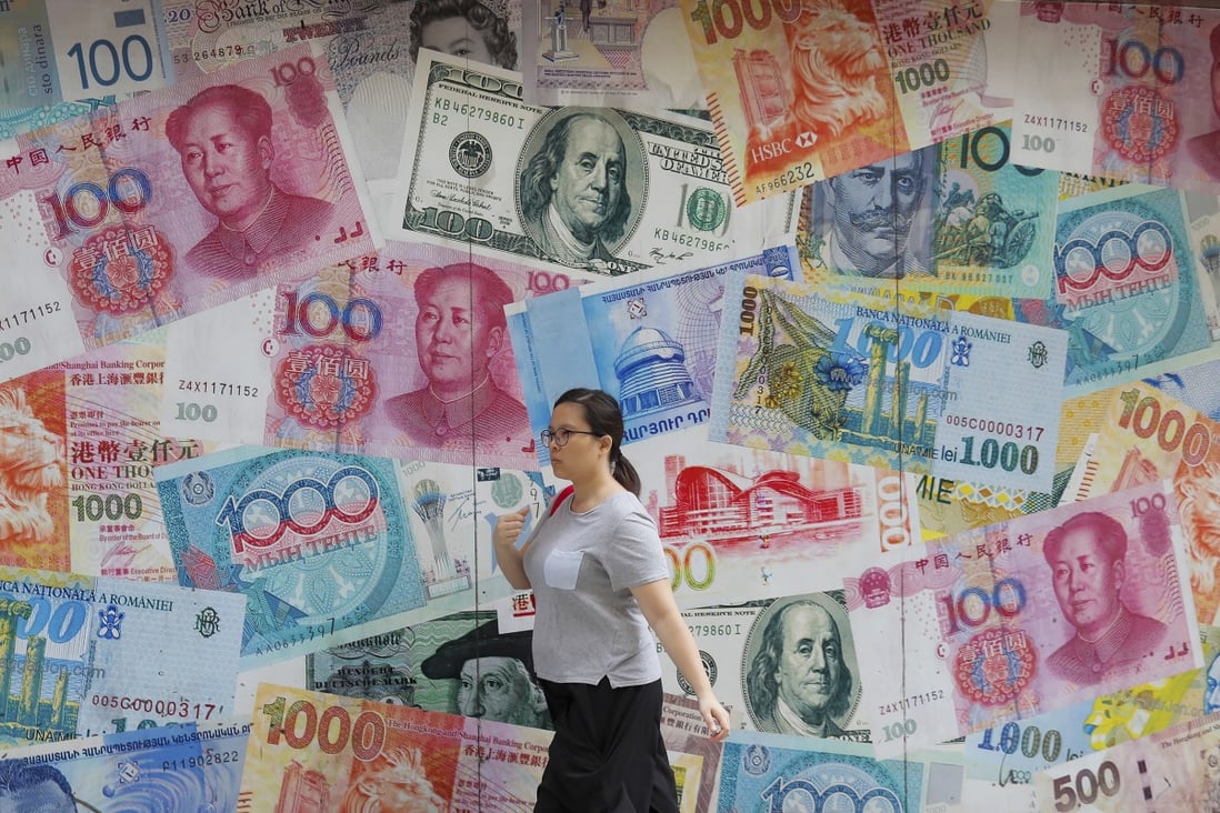 A woman walks by a money exchange shop decorated with various banknotes at Central. Overall currency deposits in Hong Kong’s banking system edged up by 0.2 per cent month on month in August. Photo: AP Photo