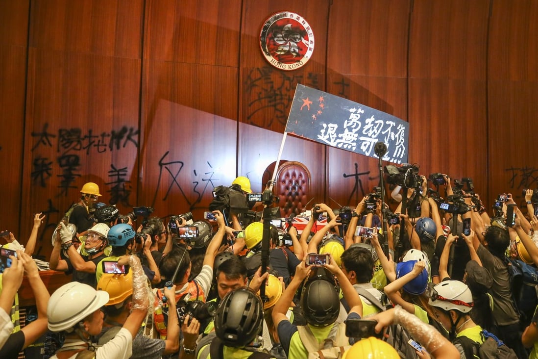 Protesters storm the legislature on July 1 as reporters rush to take pictures of the unprecedented event. Photo: Winson Wong