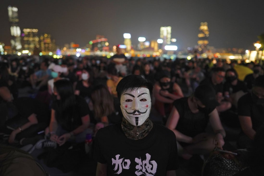 A protester wearing a mask joins others at a rally at Tamar Park in Hong Kong on Saturday, September 28, to mark the fifth anniversary of the start of the 2014 Occupy movement. Photo: AP