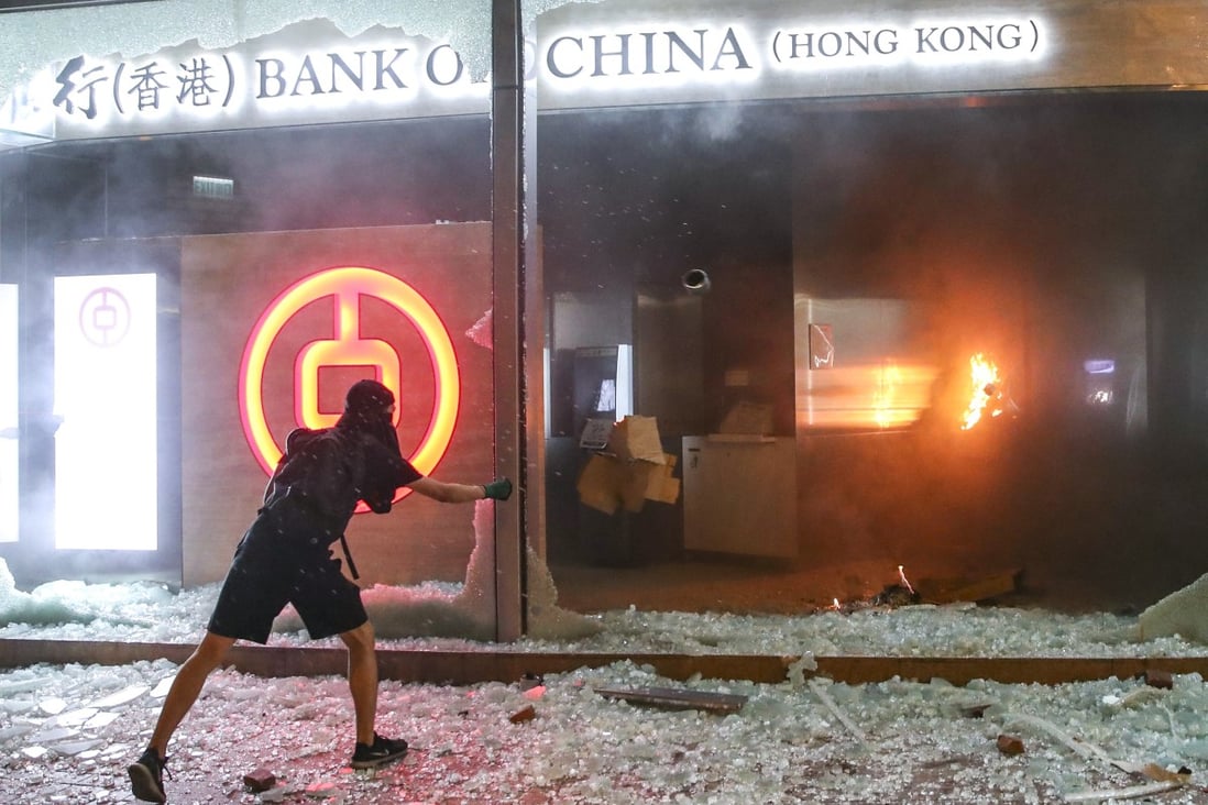 A protester sets a Bank of China branch in Tsuen Wan on fire during a rally against the government’s announcement of a ban on wearing masks at public assemblies in Hong Kong. Photo: Winson Wong