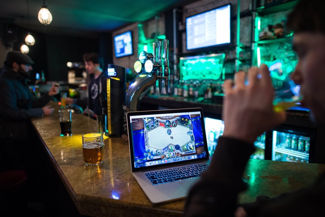 A gamer drinks a beer as he takes part in a Hearthstone tournament in London. Photo: AFP