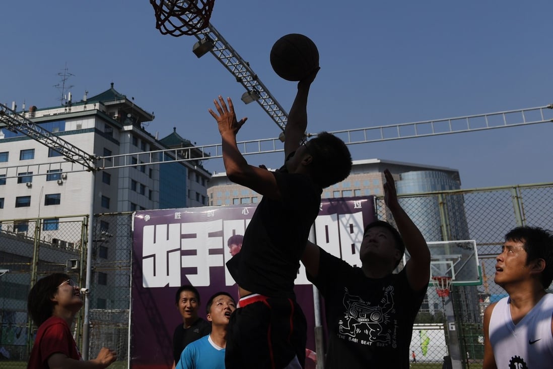 People play basketball on an outdoor court in Beijing. Photo: AFP