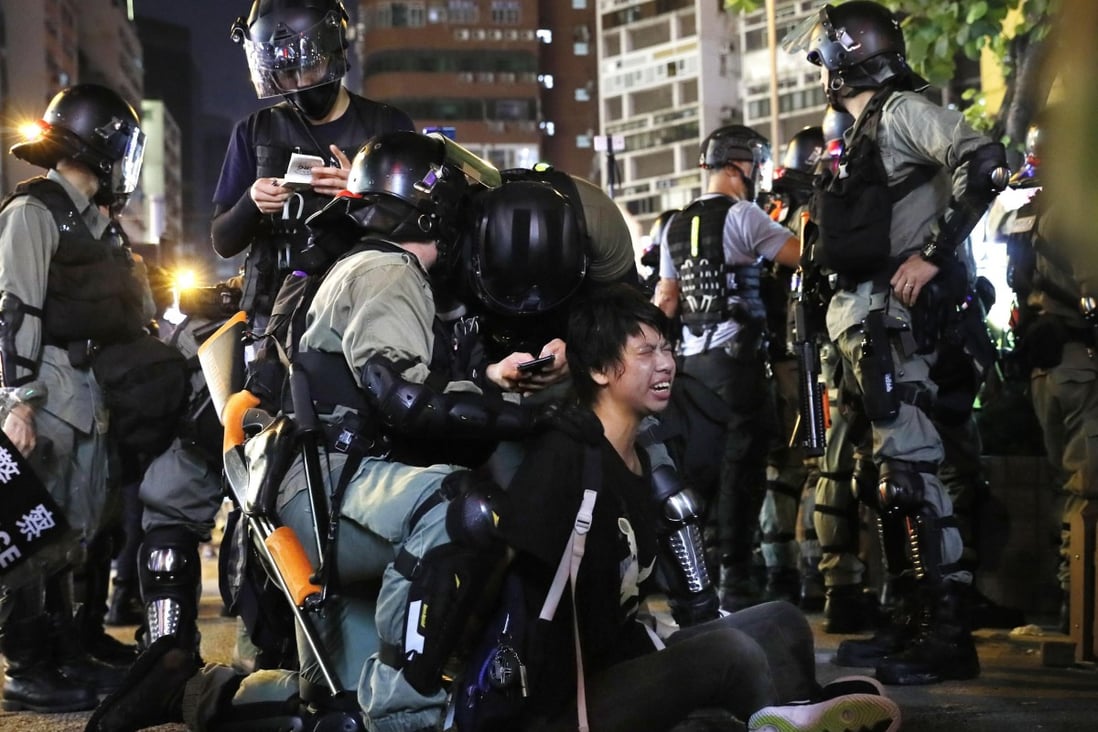 Police restrain a protester near a police station in the Mong Kok shopping district on Monday. Chinese commentators are criticising Apple Inc for making available an app that would allow users to avoid police actions in Hong Kong. Photo: Kyodo