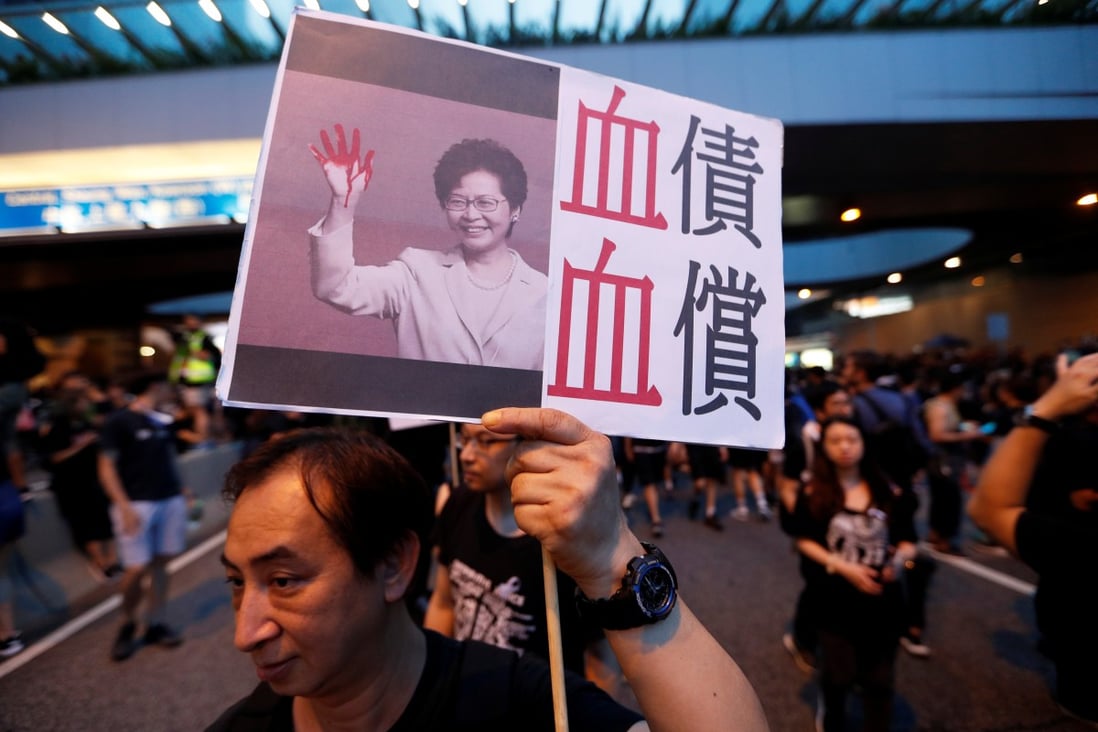 A protester holds a placard criticising Hong Kong Chief Executive Carrie Lam during a march on June 16. Photo: Reuters